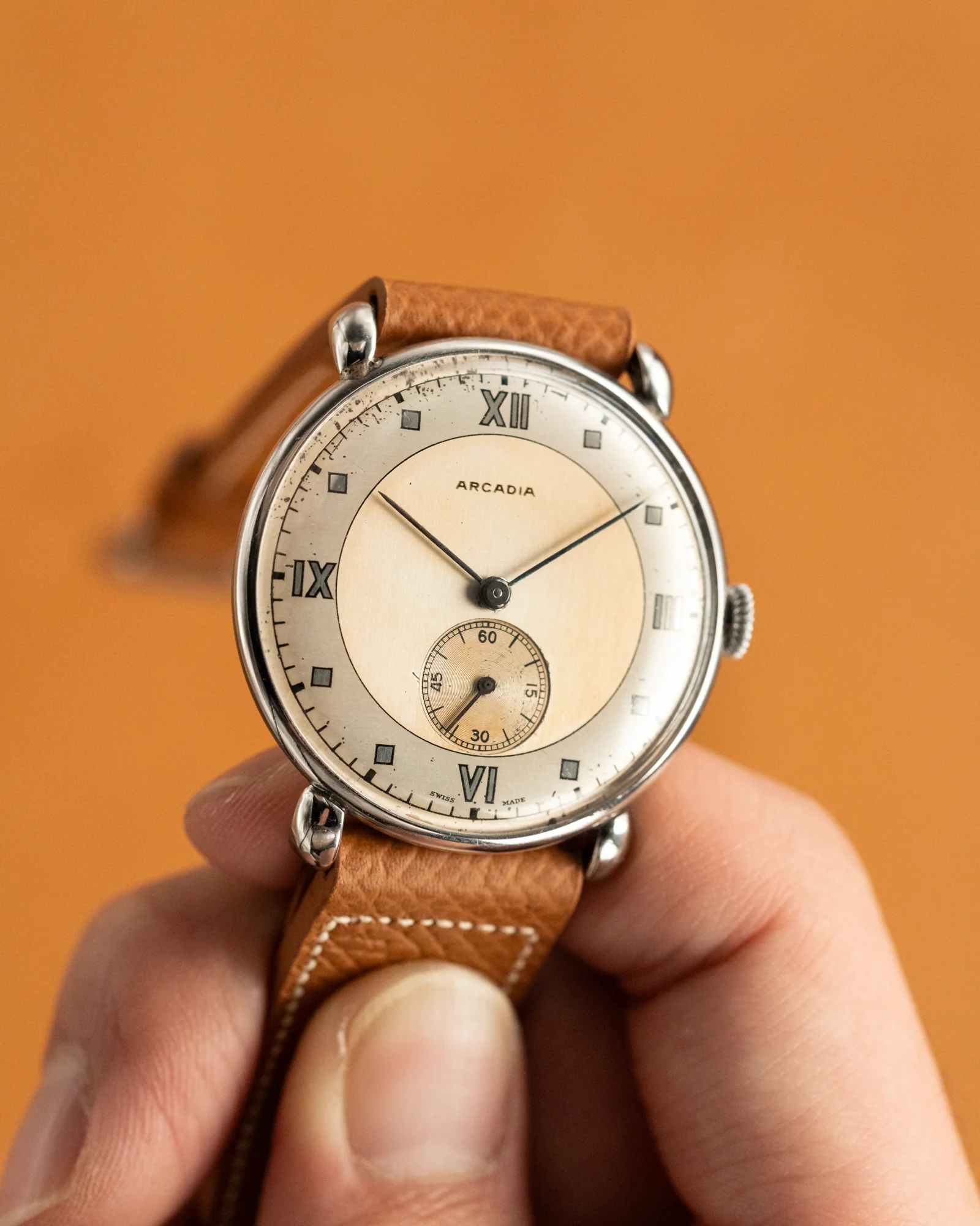 An analog watch held in a hand